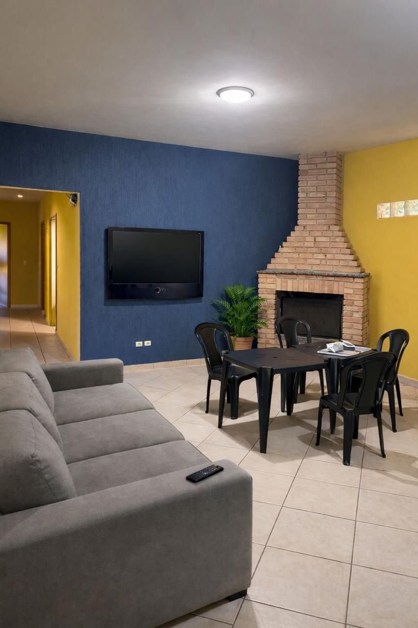 Sala de convivência com televisão e lareira