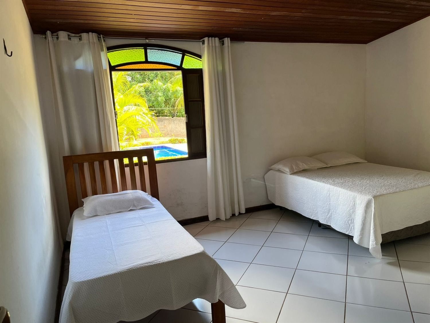 Quarto com teto de madeira e janela