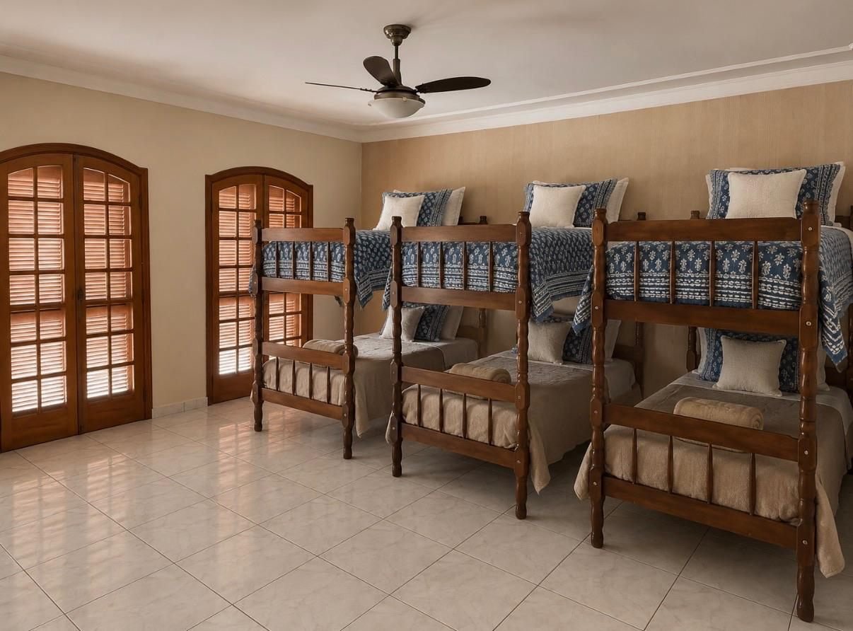 Dormitório coletivo com beliches e roupa de cama organizada
