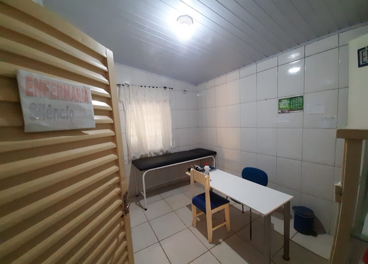 Sala de enfermaria com maca e mesa de atendimento